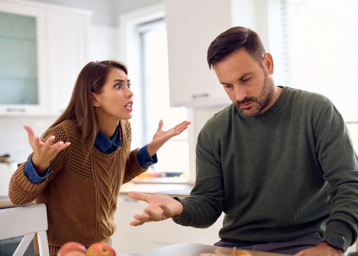 Angry woman having discussion with her husband at home.