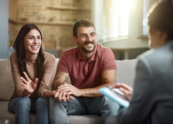 Young happy couple talking about their love with a marriage counselor at home.