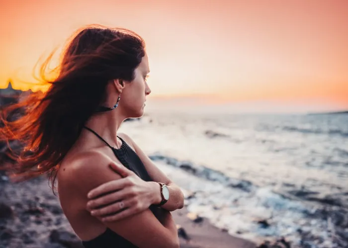 Girl in melancholy mood standing at the beach