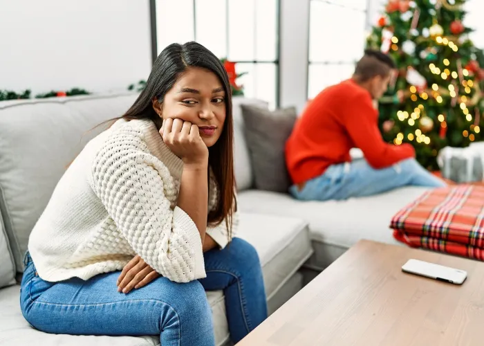 Young latin couple on problems with sad expression sitting on the sofa at home.