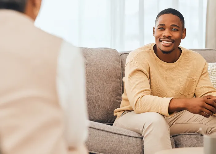 Black man, counseling and psychology consulting for therapy, mental healthcare or support. Happy patient talking to psychologist, therapist and medical help in consultation, advice and wellness check