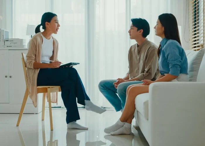 Asian female psychotherapist advising couple after consult about mental health and relationship. Professional social worker assist married couples with empathy concepts.